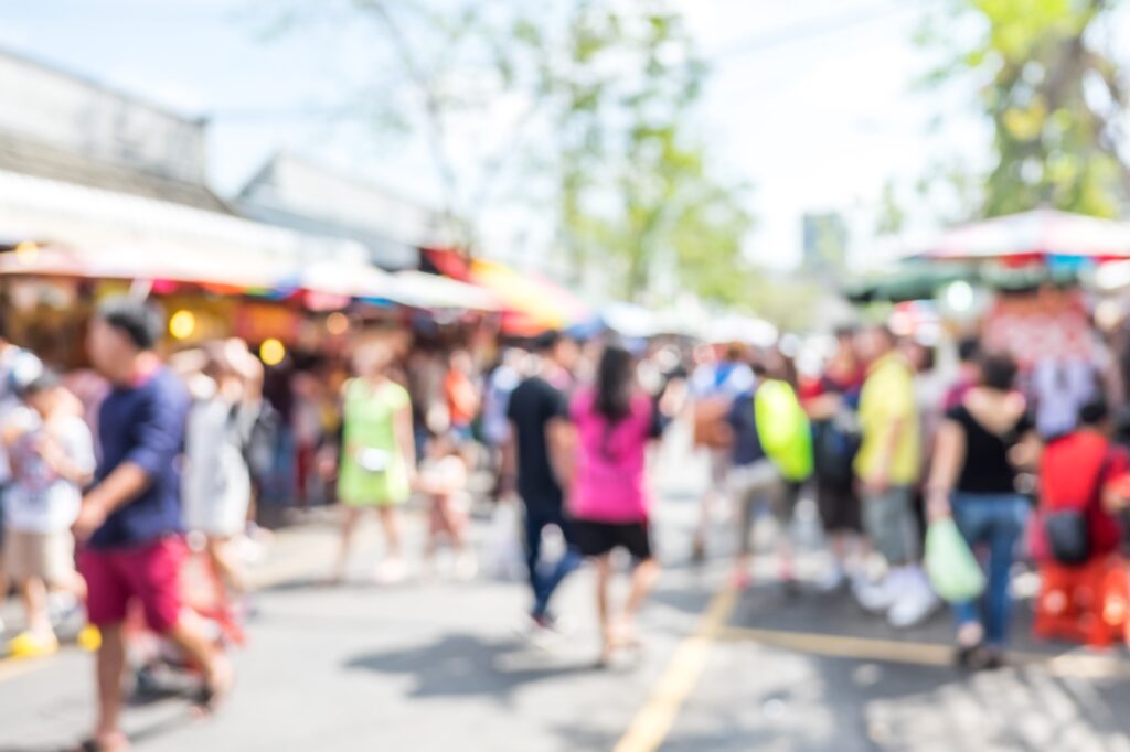 Blurred background : people shopping at market fair in sunny day, blur background with bokeh