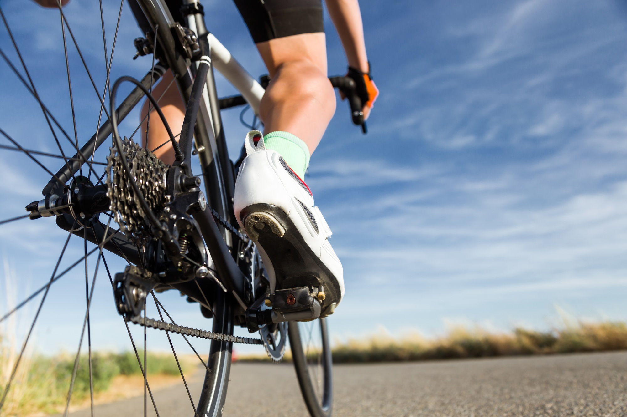 Close-up of the foot of a young man cycling.